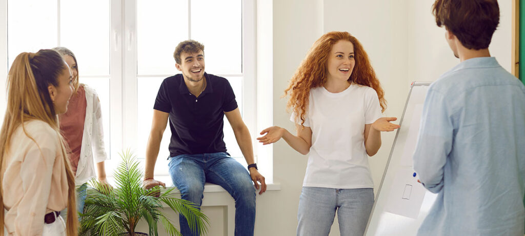 Ragazza che parla davanti un gruppo di persone